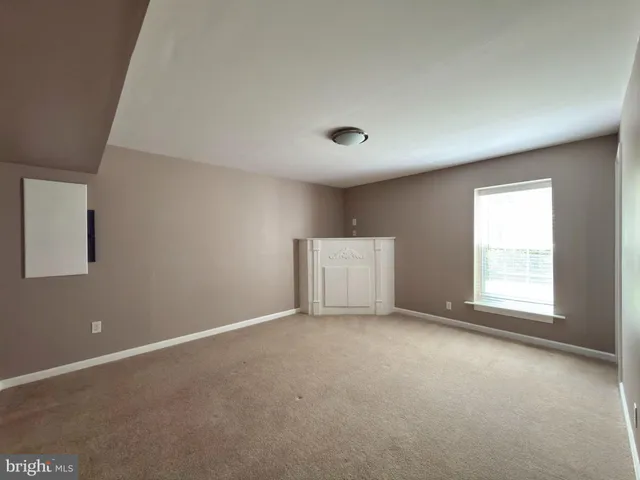 a view of an empty room with window and closet area
