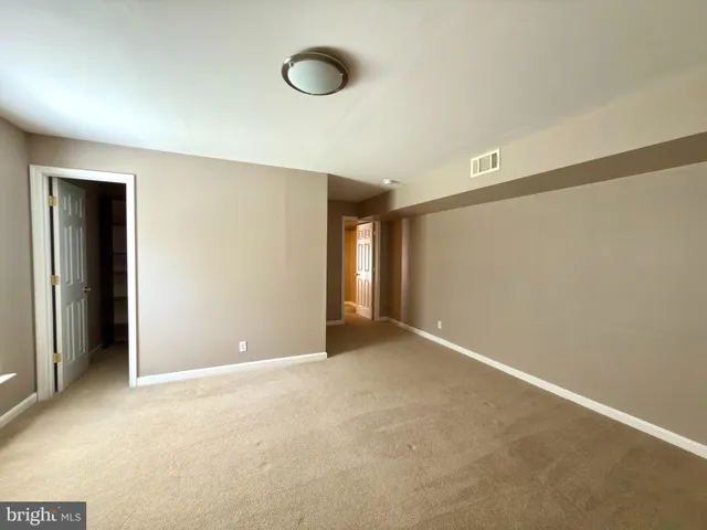 an empty room with windows and closet