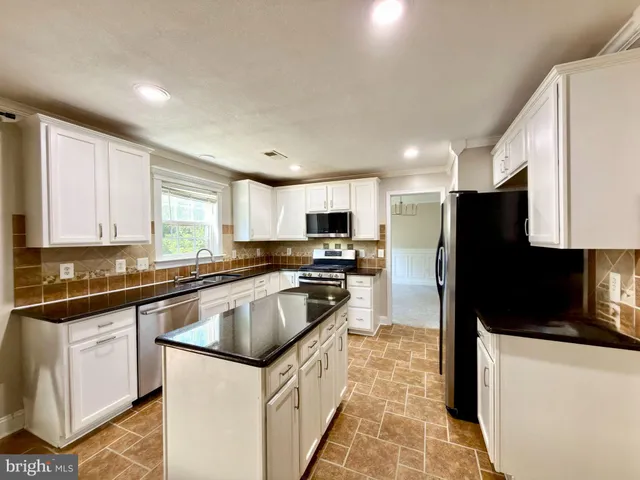 a kitchen with granite countertop a refrigerator and a sink