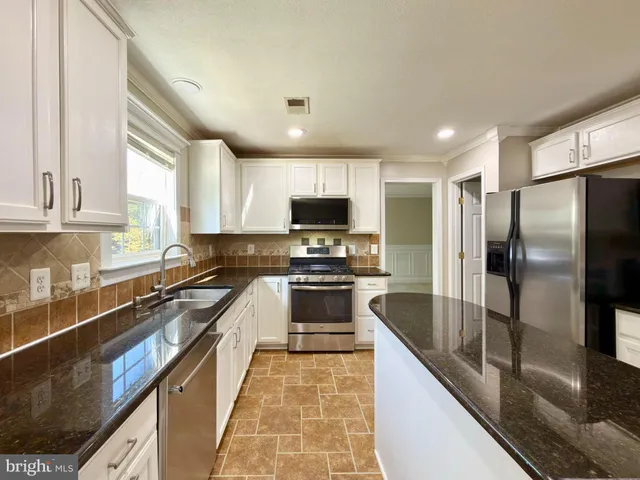 a large white kitchen with a large window
