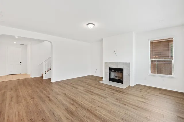 a view of empty room with wooden floor and fireplace