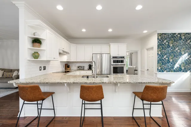 a living room with a fireplace a sink and potted plants