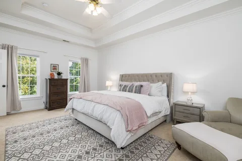 a living room with furniture a potted plant and kitchen view