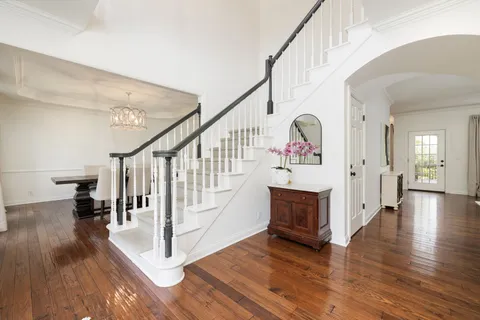 a view of a dining room with furniture a chandelier and wooden floor