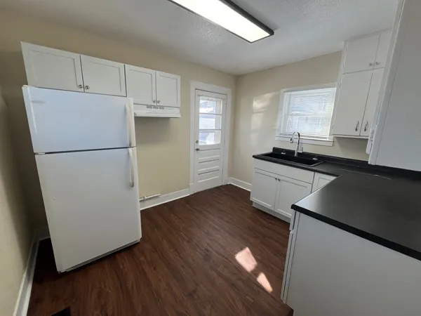 a kitchen with a refrigerator and a stove top oven