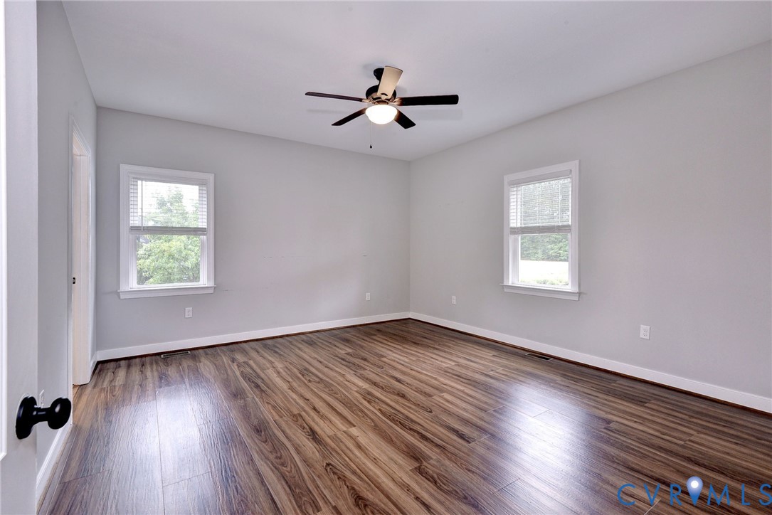 8904 Rock Cedar Road New Kent, VA 23124 - Photo 15 of 37 an empty room with wooden floor chandelier fan and windows