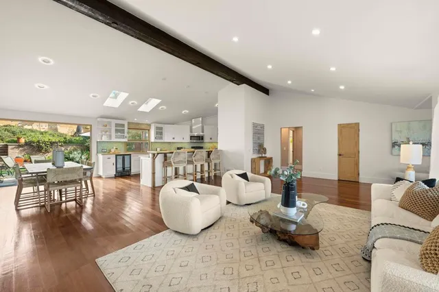 a kitchen with a stove a sink a kitchen island with chairs and wooden cabinets