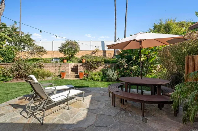 a view of a wooden chair and table in the backyard