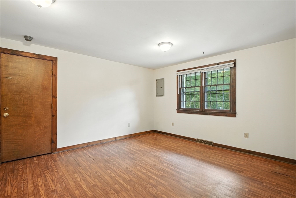 167 Warren Wright Road Belchertown, MA 01007 - Photo 12 of 42 an empty room with wooden floor and windows