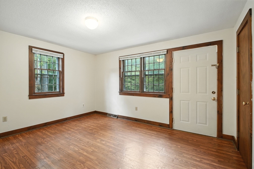 167 Warren Wright Road Belchertown, MA 01007 - Photo 13 of 42 an empty room with wooden floor and windows