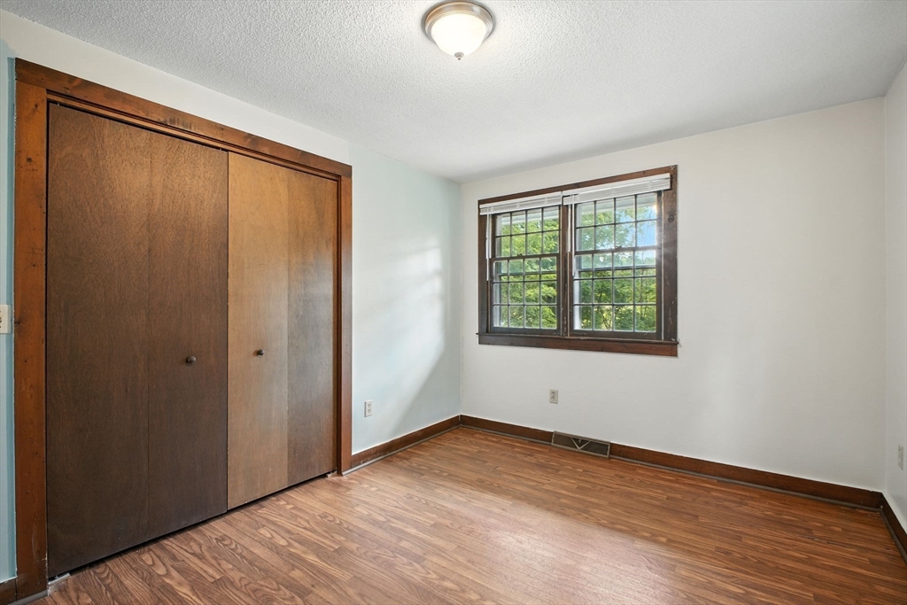 167 Warren Wright Road Belchertown, MA 01007 - Photo 17 of 42 a view of an empty room with wooden floor and a window