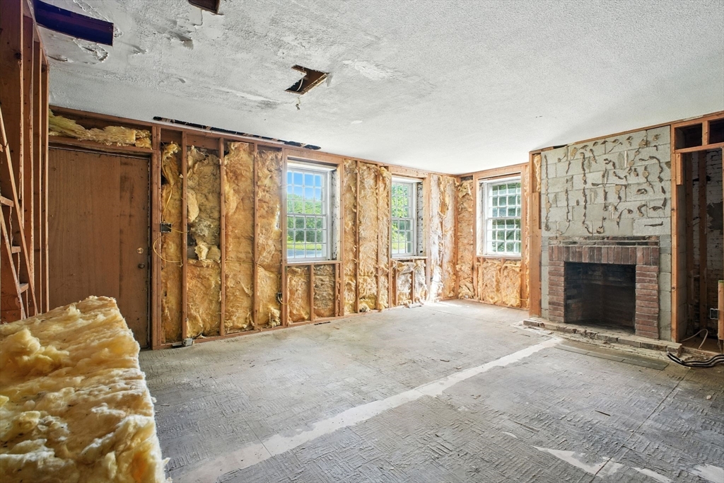 167 Warren Wright Road Belchertown, MA 01007 - Photo 34 of 42 a view of an empty room with a fireplace and a window