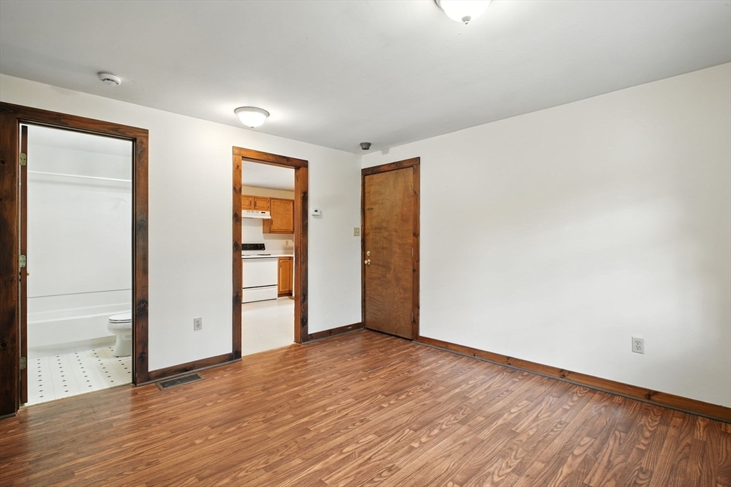 167 Warren Wright Road Belchertown, MA 01007 - Photo 7 of 42 an empty room with wooden floor and windows