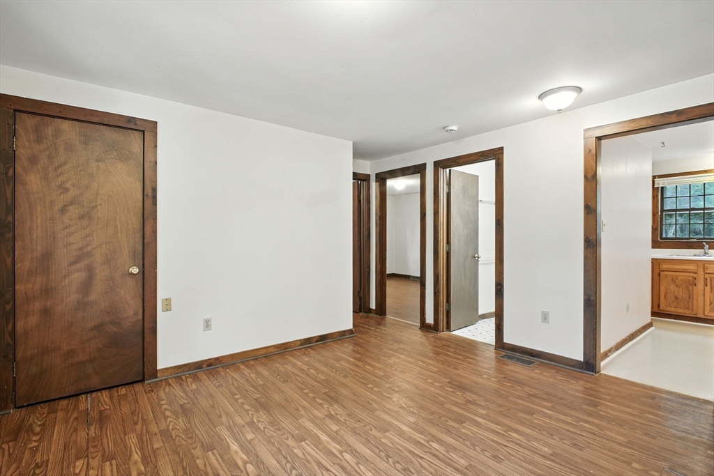 167 Warren Wright Road Belchertown, MA 01007 - Photo 8 of 42 an empty room with wooden floor and windows