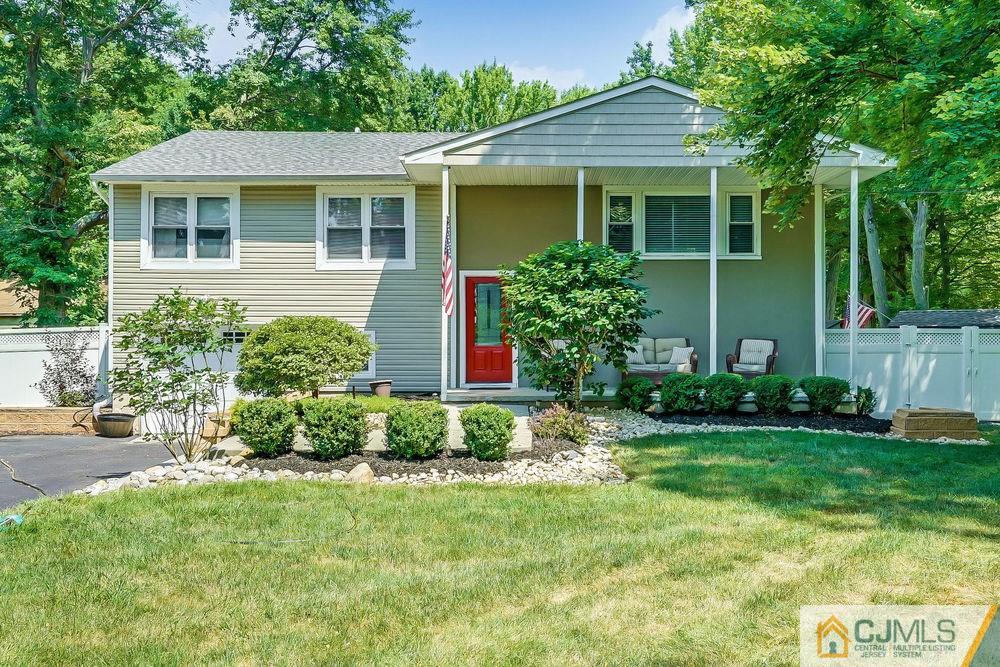 a front view of a house with a yard and potted plants