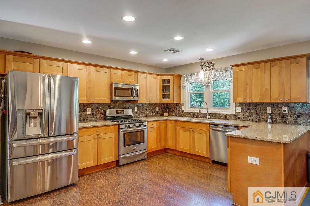334 Matchaponix Road Old Bridge, NJ 08831 - Photo 5 of 24 a kitchen with stainless steel appliances granite countertop a refrigerator a sink dishwasher a stove and white cabinets with wooden floor