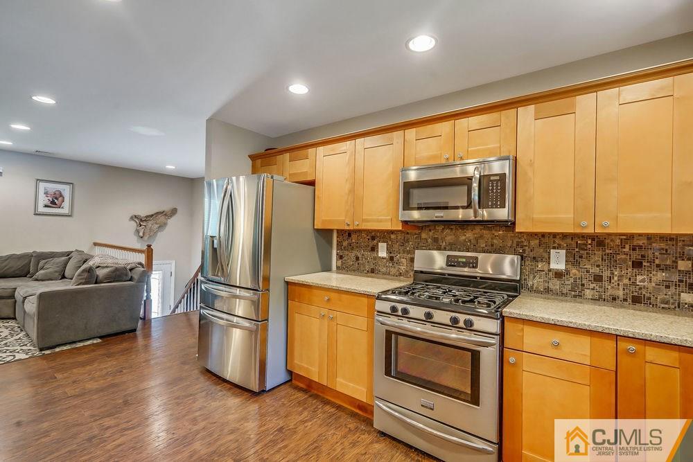 334 Matchaponix Road Old Bridge, NJ 08831 - Photo 10 of 24 a kitchen with stainless steel appliances a stove a sink a refrigerator cabinets and a window