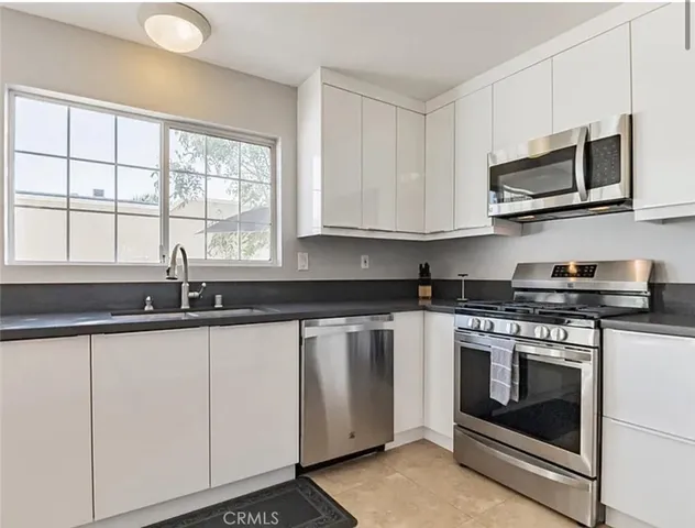 a kitchen with stainless steel appliances granite countertop a stove a microwave and a sink