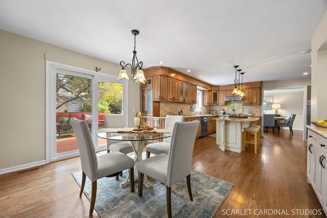a dining room with furniture a chandelier and wooden floor