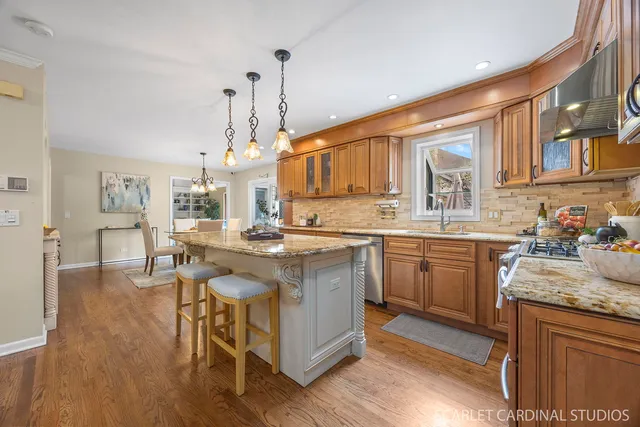a kitchen with kitchen island granite countertop a sink cabinets and wooden floor