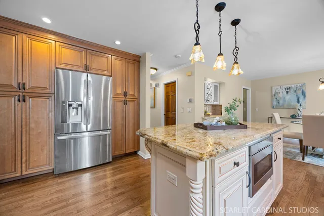 a kitchen with a stove a refrigerator a sink and dishwasher with wooden floor