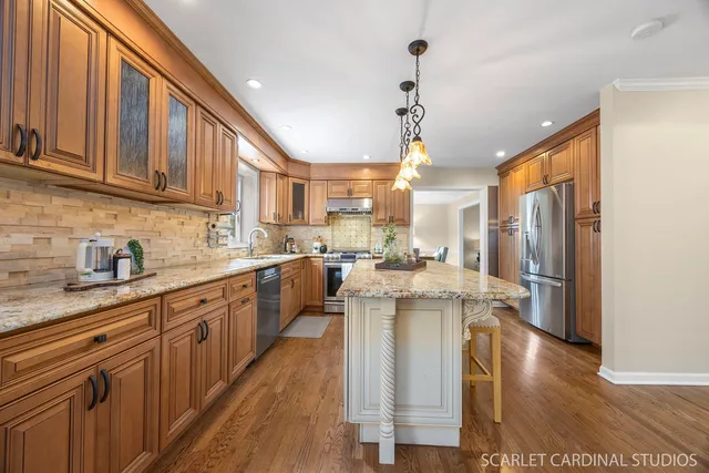 a kitchen with stainless steel appliances granite countertop a sink stove and refrigerator