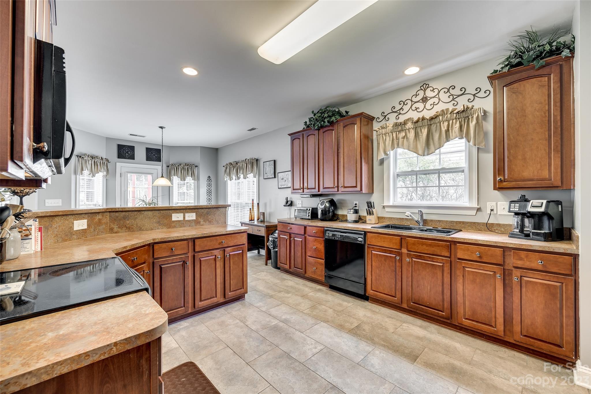 5540 Alexandrite Way Fort Mill, SC 29708 - Photo 15 of 46 a large kitchen with stainless steel appliances granite countertop a sink counter space cabinets and a large window