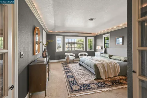 a spacious bedroom with a large bed and a chandelier