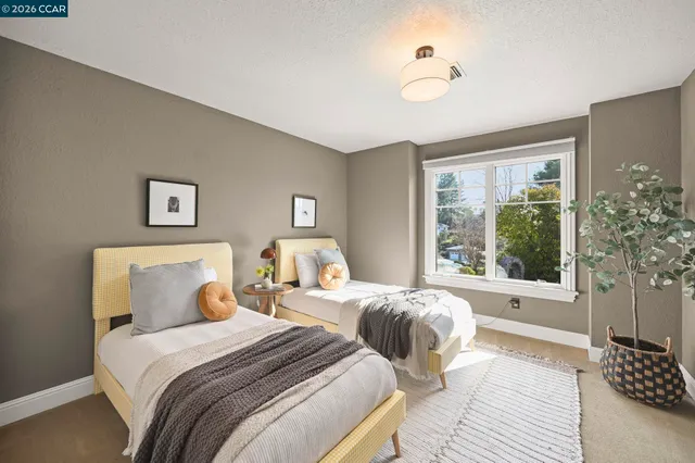 a bedroom with beds and a large window