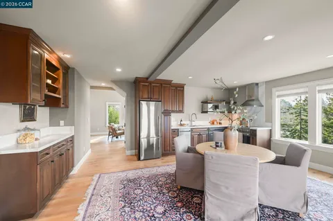 a living room with stainless steel appliances kitchen island granite countertop furniture a rug kitchen view and a large window