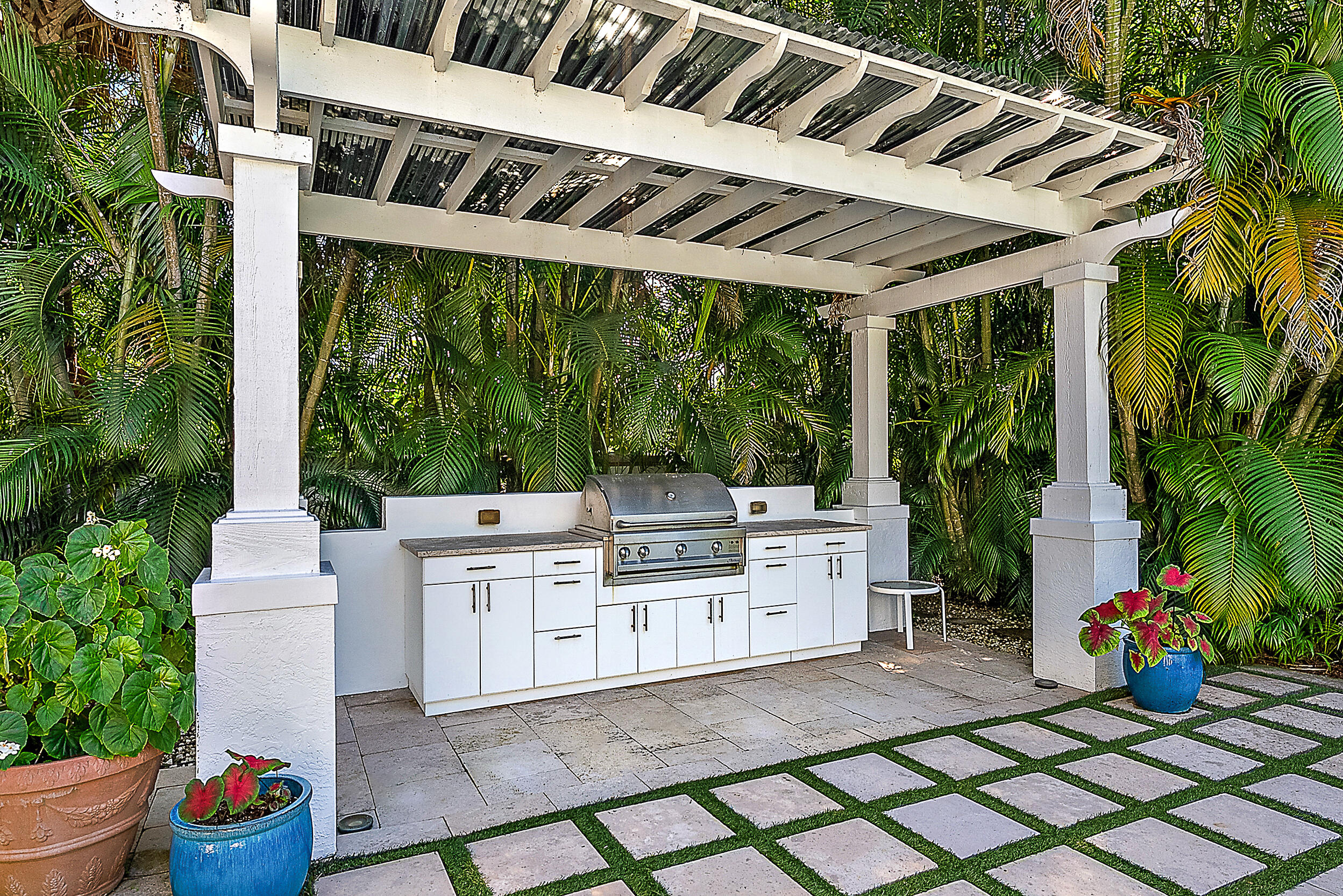 18706 Southeast St Augustine Way Jupiter, FL 33469 - Photo 28 of 74 a view of a patio with table and chairs potted plants and palm tree