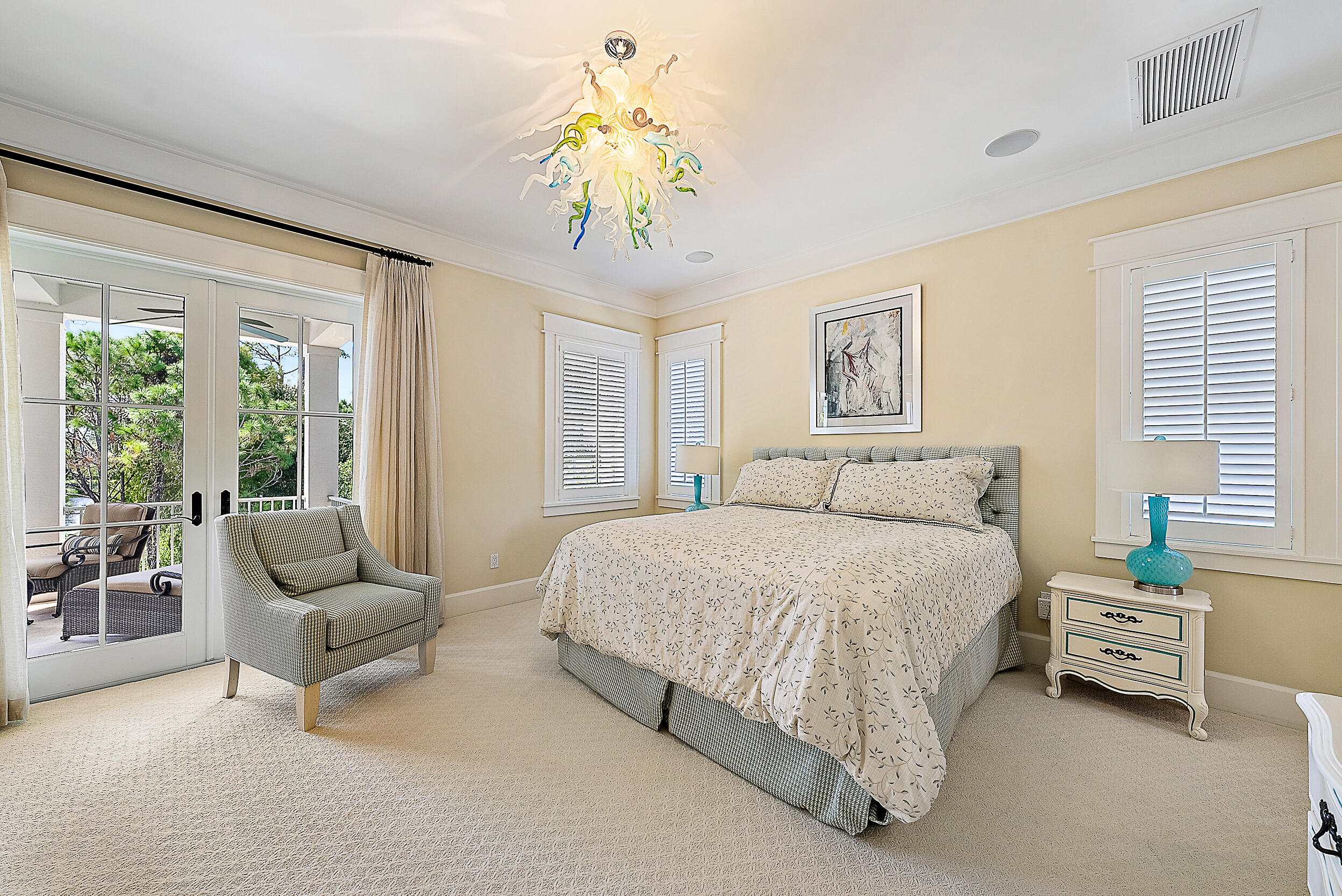 18706 Southeast St Augustine Way Jupiter, FL 33469 - Photo 45 of 74 a spacious bedroom with a bed and a chandelier