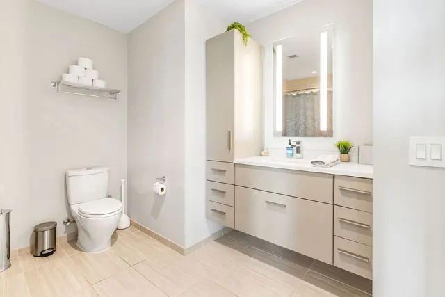a bathroom with a sink vanity mirror and toilet
