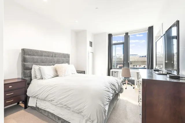 a bedroom with a large bed and a large window