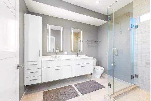 a bathroom with a double vanity sink mirror and toilet