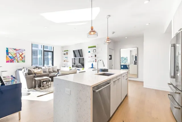 a kitchen with a sink stove and wooden floor