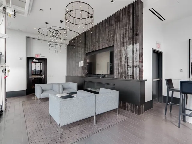 a living room with furniture a flat screen tv and a large window