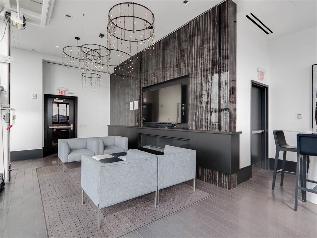 40 Traveler Street, Unit 303 Boston, MA 02118 - Photo 37 of 42 a living room with furniture a flat screen tv and a large window