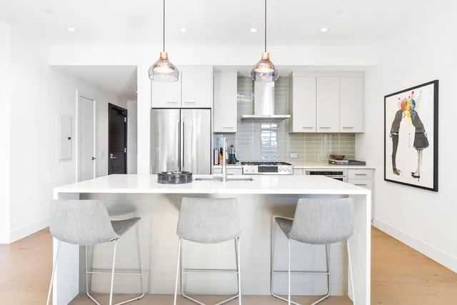 a kitchen with stainless steel appliances granite countertop a stove a sink and white cabinets