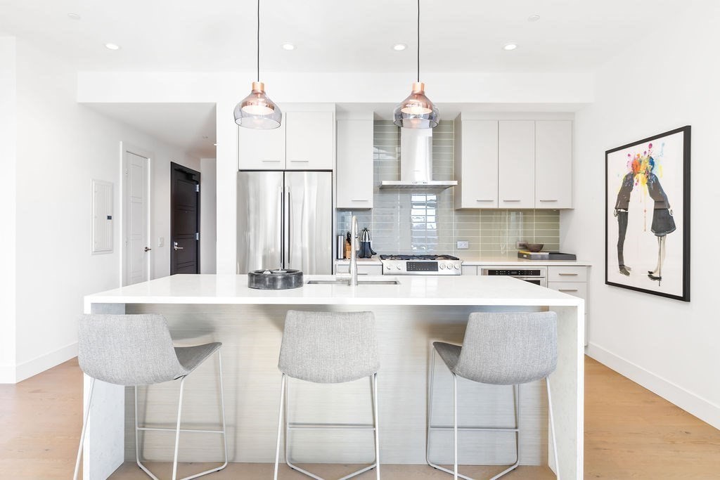 40 Traveler Street, Unit 303 Boston, MA 02118 - Photo 6 of 42 a kitchen with stainless steel appliances granite countertop a stove a sink and white cabinets