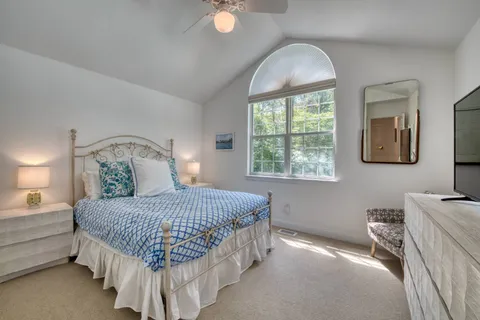 a bedroom with a bed mirror and window