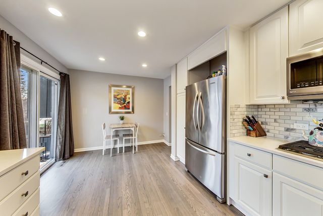a kitchen with a refrigerator and a stove top oven