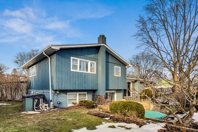 a backyard of a house with barbeque oven table and chairs