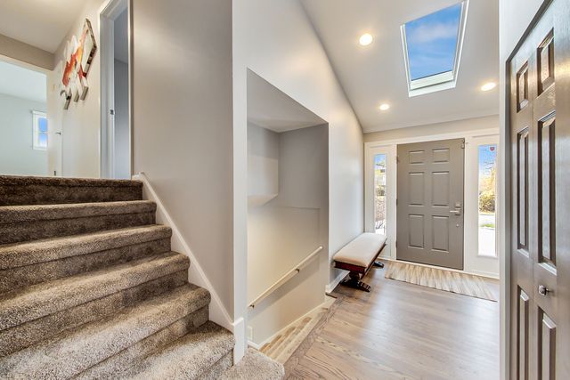 a view of a hallway with entryway wooden floor and windows