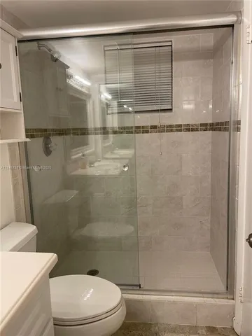 a bathroom with a shower a toilet and a shower