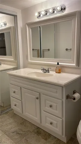 a bathroom with a sink vanity and mirror