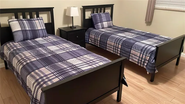 a bedroom with a bed a dresser and book shelf