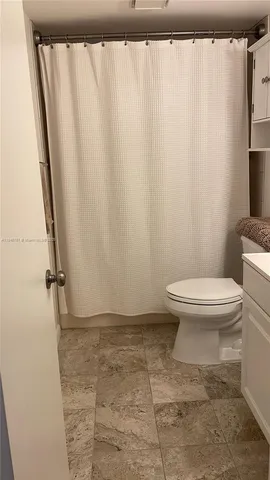 a bathroom with a toilet and a shower curtain