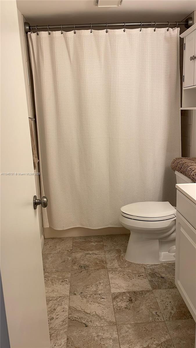 121 Southeast 3rd Avenue, Unit 201 Dania Beach, FL 33004 - Photo 26 of 49 a bathroom with a toilet and a shower curtain
