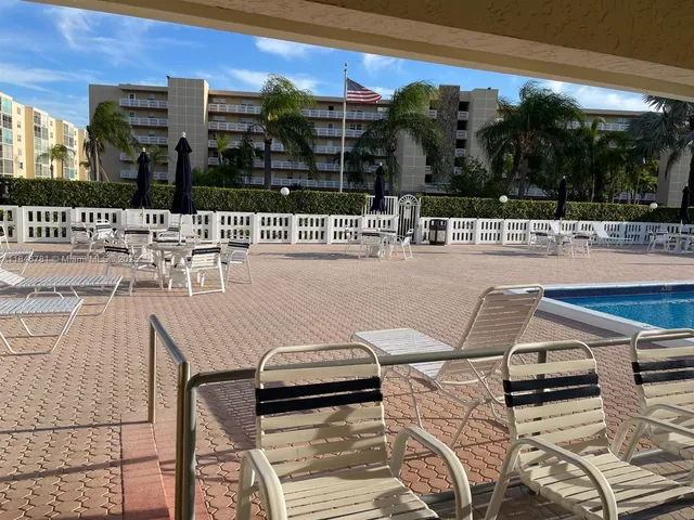 a view of a patio with chairs and potted plants